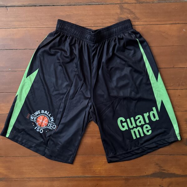 Black sports shorts with green accents and text designs.