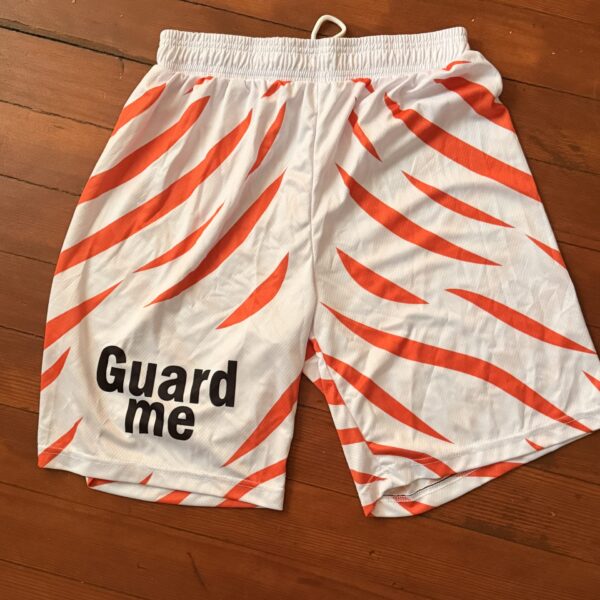 White and orange striped shorts with 'Guard me' text on the left leg.