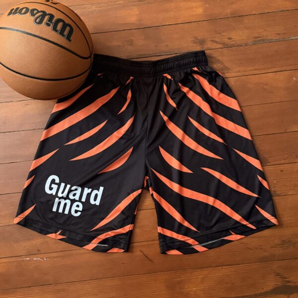 Black and orange basketball shorts with "Guard me" text and a basketball.