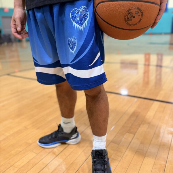 Basketball player in blue shorts holding a basketball on a court.
