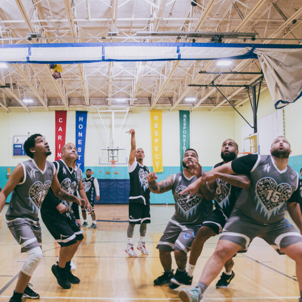 Players fiercely competing in an indoor basketball game.
