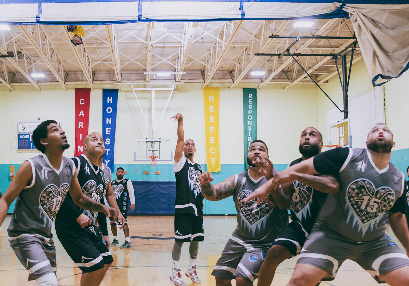 Players fiercely competing in an indoor basketball game.